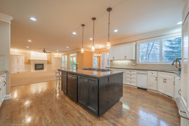 kitchen with pendant lighting, white cabinetry, a center island, and a healthy amount of sunlight