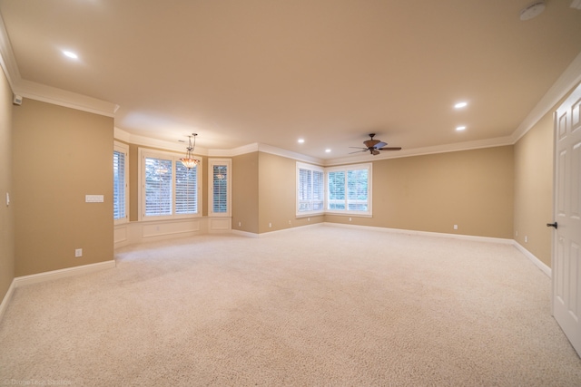 carpeted empty room featuring ceiling fan with notable chandelier and ornamental molding