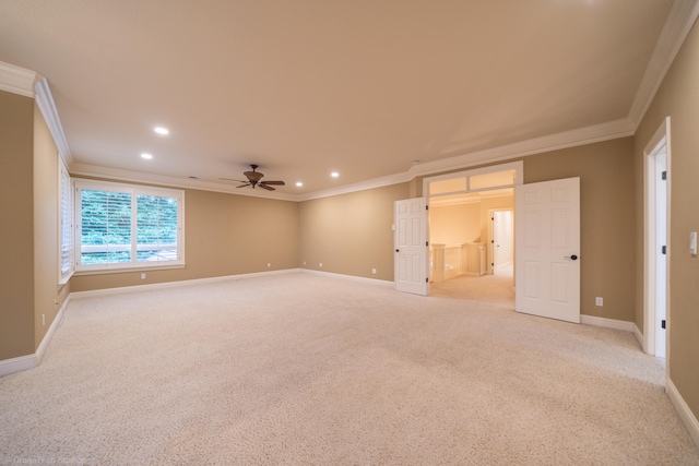 empty room featuring crown molding, ceiling fan, and light colored carpet