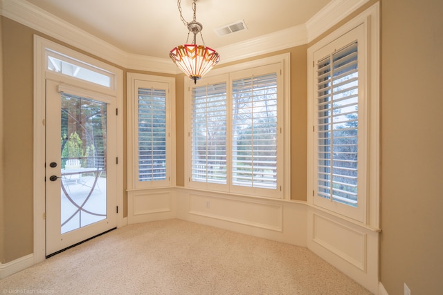 doorway with light carpet, ornamental molding, and a healthy amount of sunlight