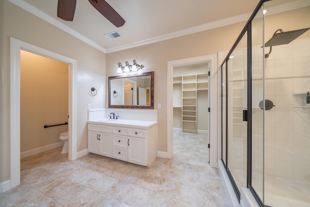 bathroom with a shower with shower door, vanity, crown molding, ceiling fan, and toilet