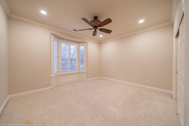 carpeted empty room with ceiling fan and crown molding