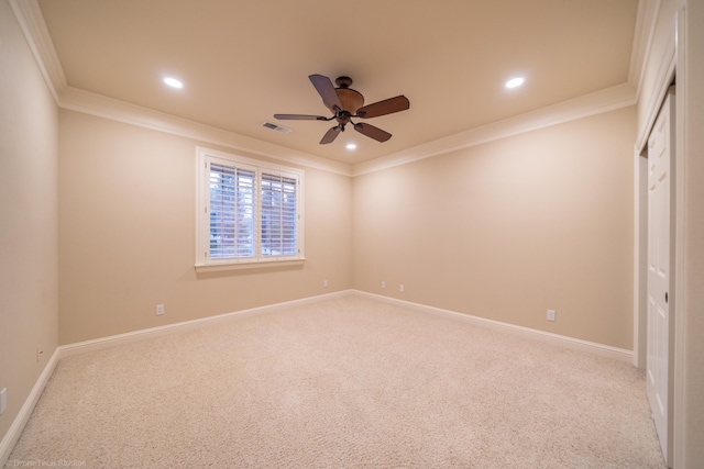 carpeted spare room with ceiling fan and ornamental molding