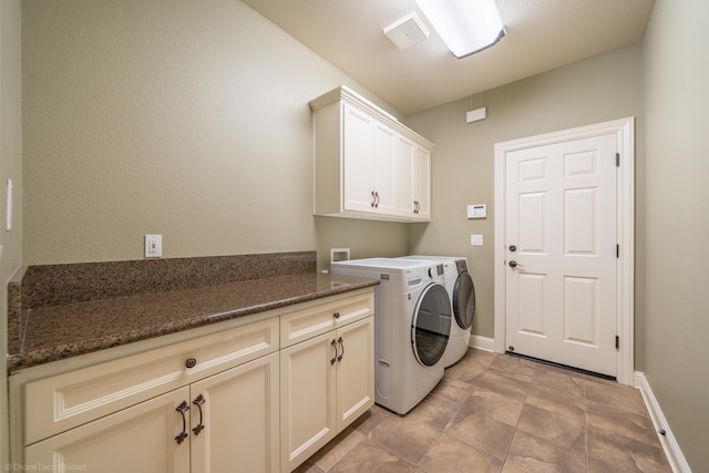 laundry room featuring washing machine and clothes dryer and cabinets