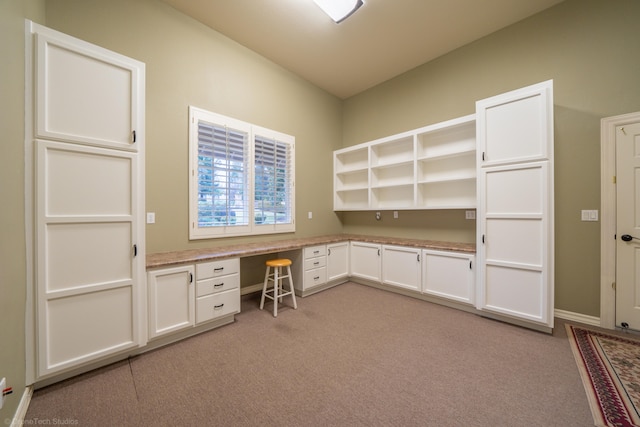 unfurnished office featuring light carpet and built in desk