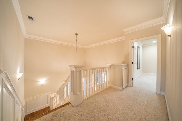 hall with crown molding and light colored carpet