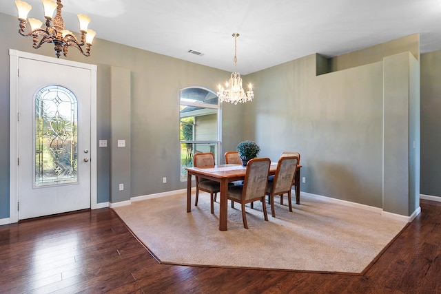 dining space with an inviting chandelier, plenty of natural light, and dark hardwood / wood-style flooring