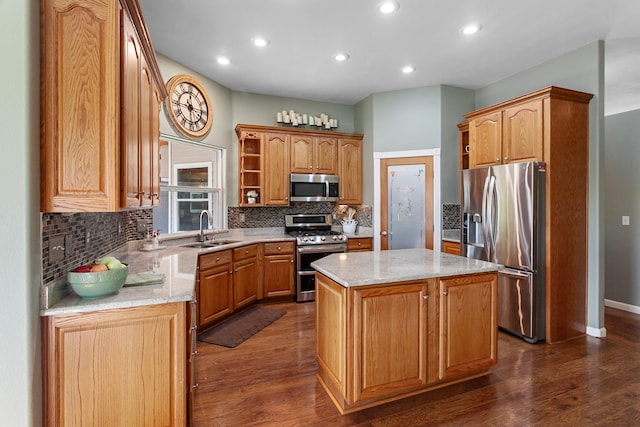 kitchen featuring light stone countertops, a center island, dark wood-type flooring, sink, and appliances with stainless steel finishes