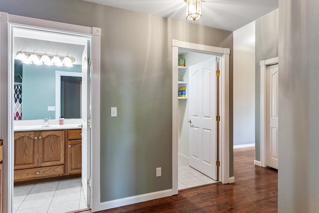 hall with light hardwood / wood-style flooring and sink