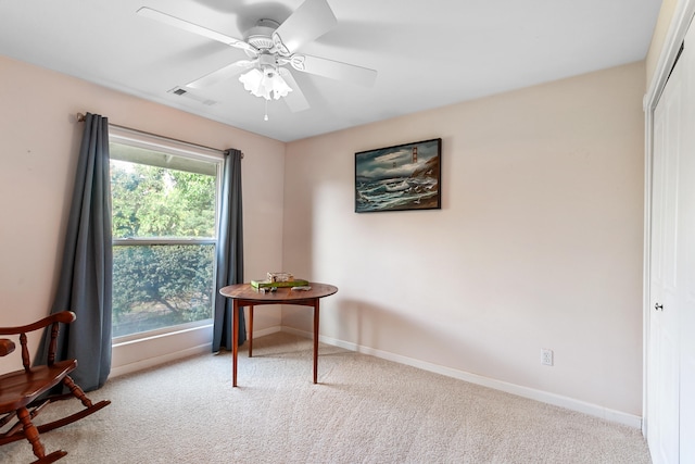 sitting room featuring light carpet and ceiling fan