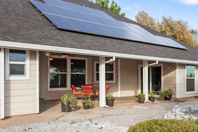 rear view of property with a patio, solar panels, and ceiling fan