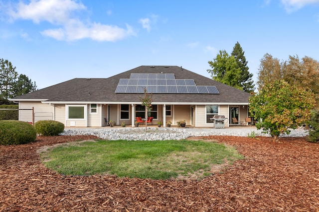 rear view of house featuring solar panels and a patio