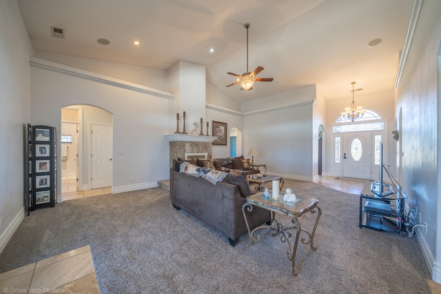 living room with ceiling fan with notable chandelier, carpet flooring, and high vaulted ceiling