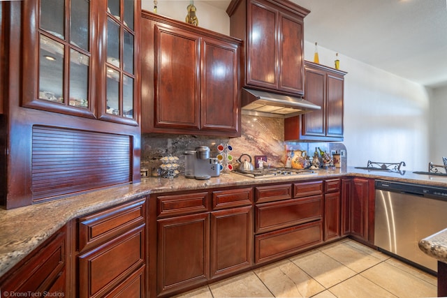 kitchen featuring light stone countertops, appliances with stainless steel finishes, light tile patterned floors, and tasteful backsplash