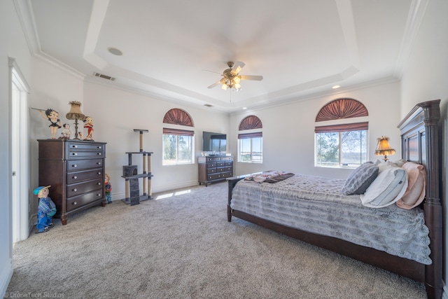 bedroom with ornamental molding, a tray ceiling, ceiling fan, and carpet flooring