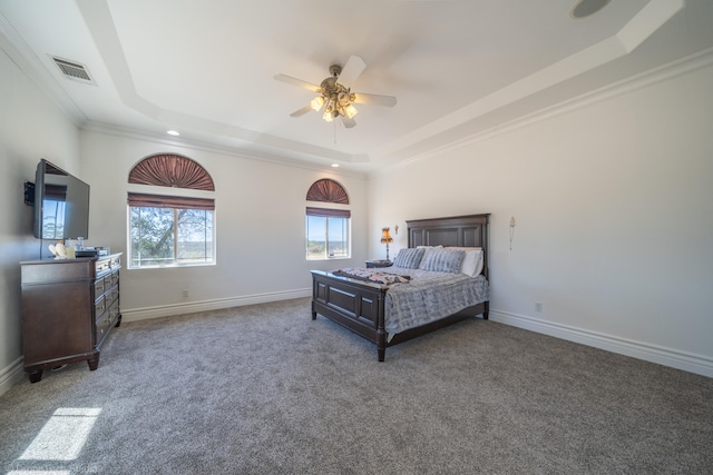 carpeted bedroom with a raised ceiling, crown molding, and ceiling fan