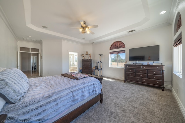 bedroom with a raised ceiling, crown molding, dark colored carpet, and ceiling fan