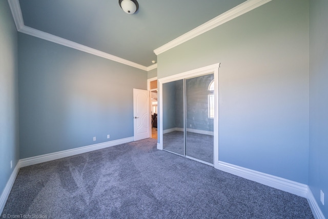 unfurnished bedroom with carpet, ornamental molding, and a closet