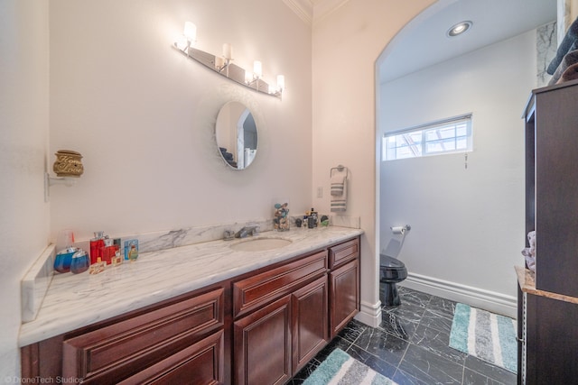 bathroom with ornamental molding, vanity, and toilet