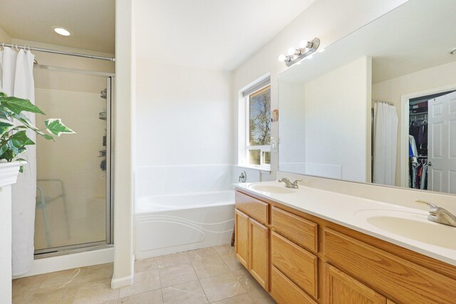 bathroom featuring plus walk in shower, tile patterned flooring, and vanity