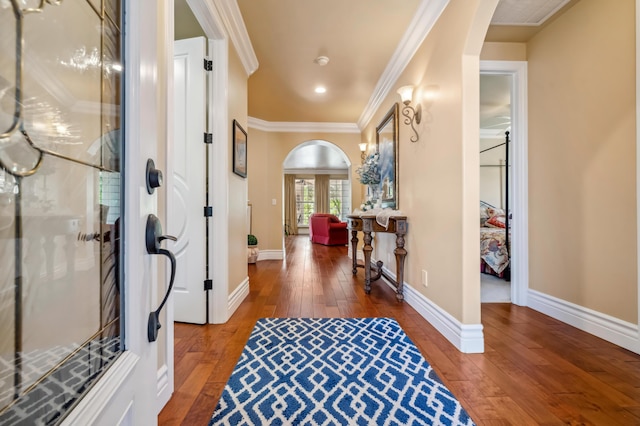 foyer entrance with ornamental molding and dark hardwood / wood-style flooring