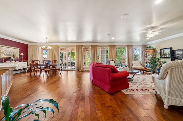 living room with ornamental molding, hardwood / wood-style floors, and ceiling fan with notable chandelier