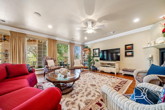 living room with ceiling fan, ornamental molding, and wood-type flooring