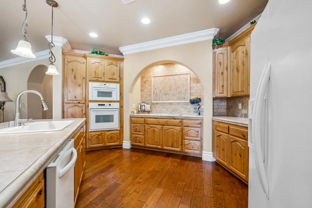 kitchen with white appliances, dark hardwood / wood-style flooring, decorative light fixtures, sink, and ornamental molding