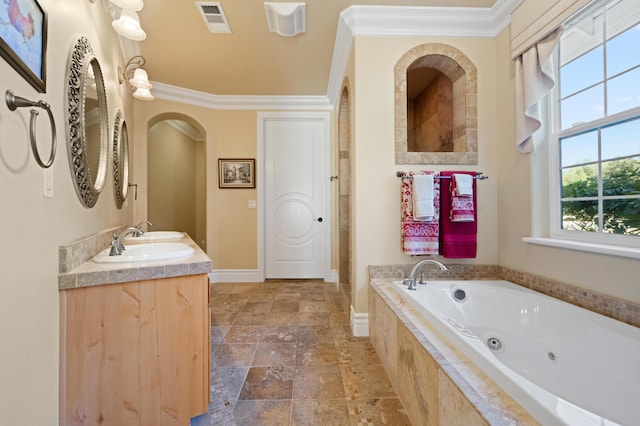 bathroom featuring tiled bath, ornamental molding, and vanity