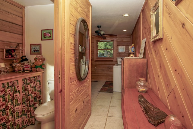 interior space with wooden walls, toilet, ceiling fan, and tile patterned floors