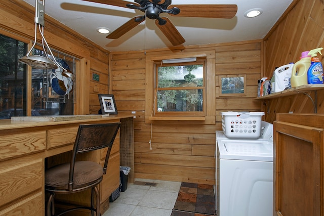 laundry room featuring light tile patterned flooring, wooden walls, ceiling fan, and washing machine and clothes dryer