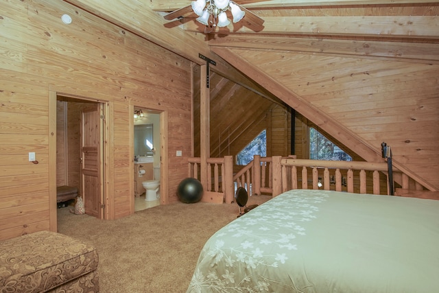 bedroom with vaulted ceiling, carpet floors, wood walls, ceiling fan, and ensuite bathroom