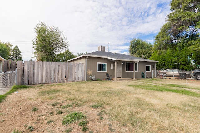 view of front of property with central AC and a front lawn