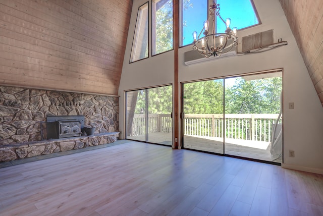 unfurnished living room featuring a healthy amount of sunlight, an inviting chandelier, and a towering ceiling