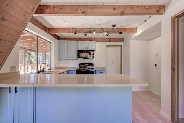 kitchen with black appliances, light hardwood / wood-style floors, beamed ceiling, kitchen peninsula, and sink