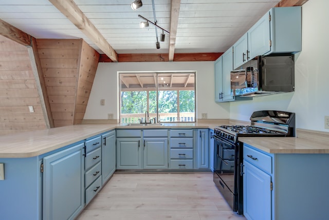 kitchen with sink, beamed ceiling, kitchen peninsula, rail lighting, and black appliances