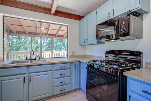 kitchen with sink, light hardwood / wood-style floors, black appliances, and beamed ceiling