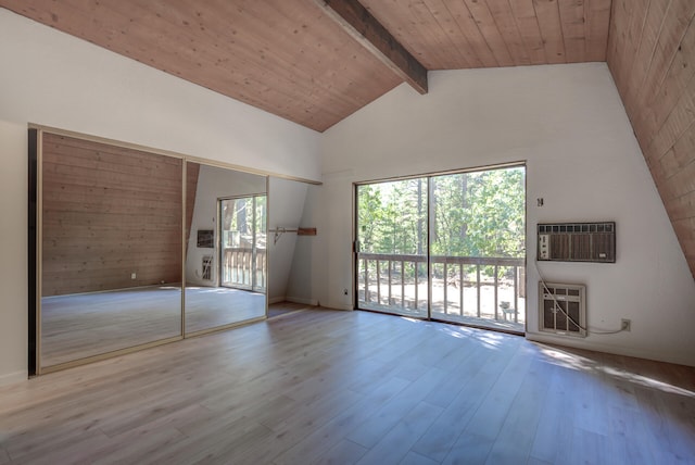 empty room featuring wooden ceiling, heating unit, a wall unit AC, light hardwood / wood-style floors, and beamed ceiling