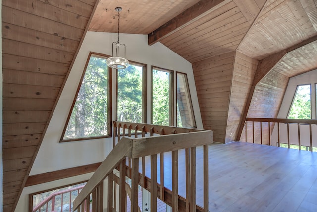 additional living space featuring a chandelier, lofted ceiling with beams, wood ceiling, and hardwood / wood-style floors