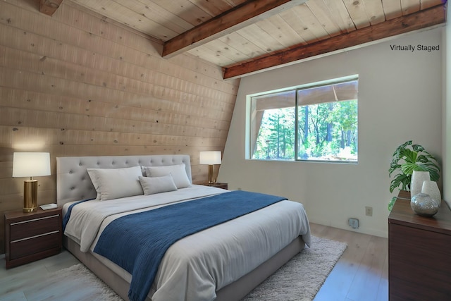 bedroom with light wood-type flooring, beam ceiling, and wood ceiling