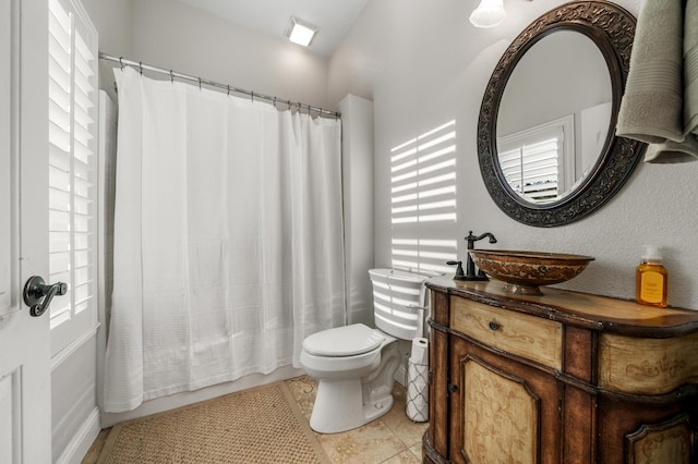 full bathroom with a wealth of natural light, vanity, toilet, and tile patterned floors