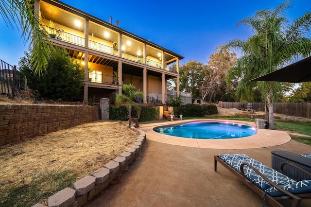 pool at dusk featuring a patio