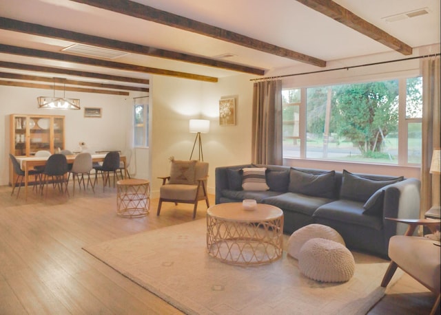 living room with light hardwood / wood-style flooring and beamed ceiling