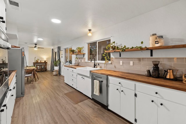 kitchen with light hardwood / wood-style flooring, white cabinets, appliances with stainless steel finishes, and sink