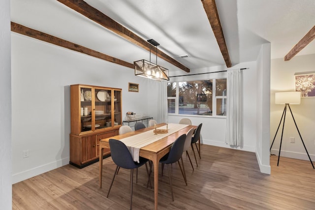 dining room with beamed ceiling and light hardwood / wood-style flooring