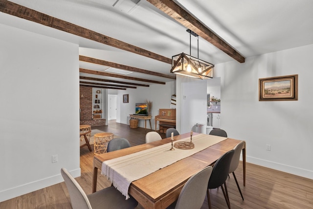 dining space with hardwood / wood-style flooring and beam ceiling