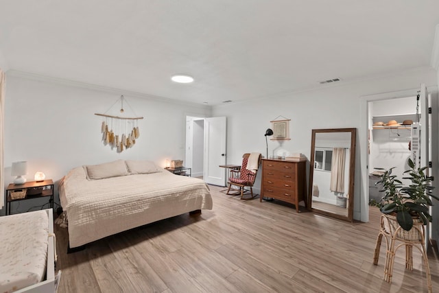 bedroom with crown molding and light hardwood / wood-style floors