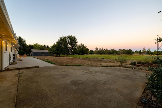 yard at dusk featuring a patio