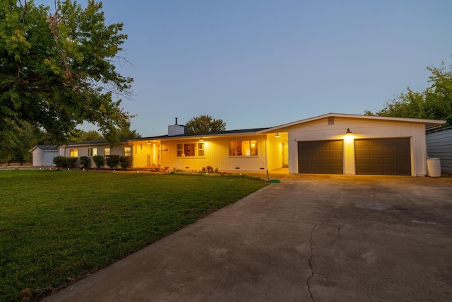 single story home featuring a lawn and a garage