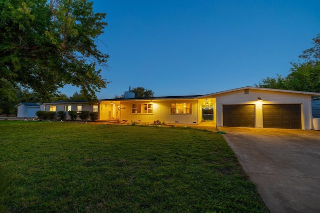 single story home featuring a lawn and a garage